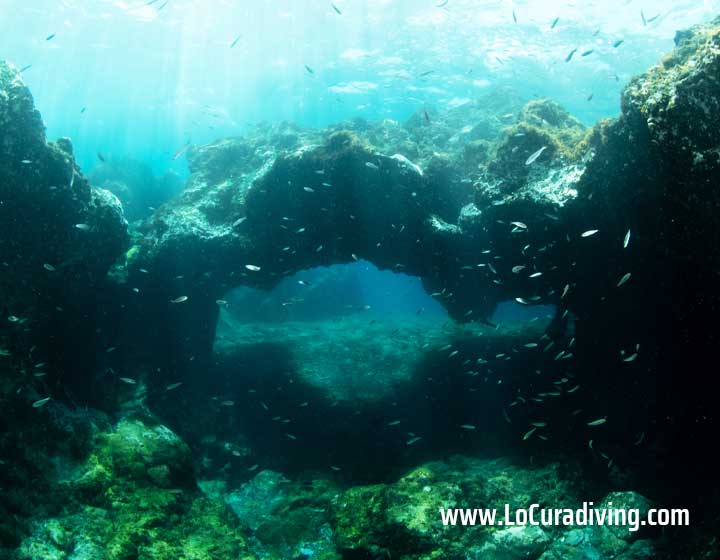 Entrance of a cavern at El Balito, showing clear waters and light streaming inside.