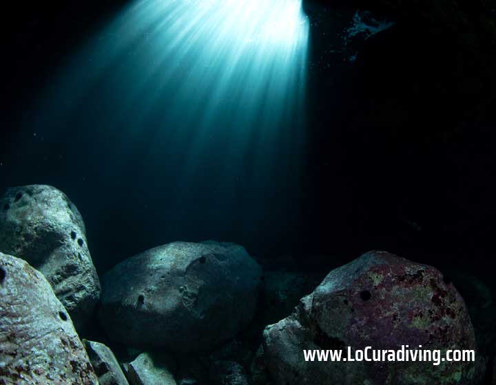Inside view of a cavern at El Balito with a ray of light shining through an opening.