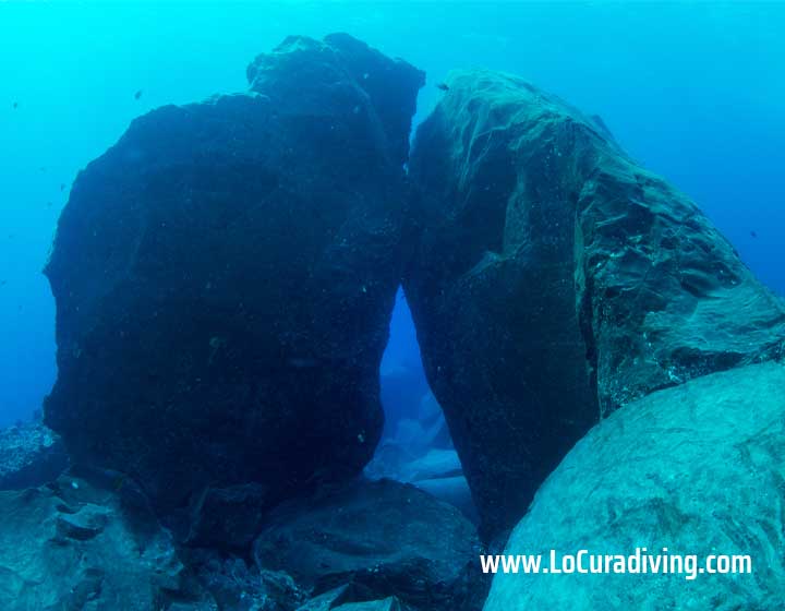 Two massive rocks forming a swim-through at El Balito dive site.