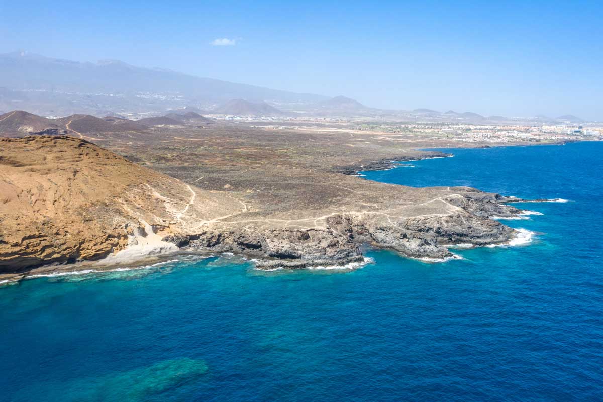 Aerial view of Montana Amarilla, a dive site in Tenerife, showcasing the coastline and underwater reef with stunning rock formations and crystal-clear waters