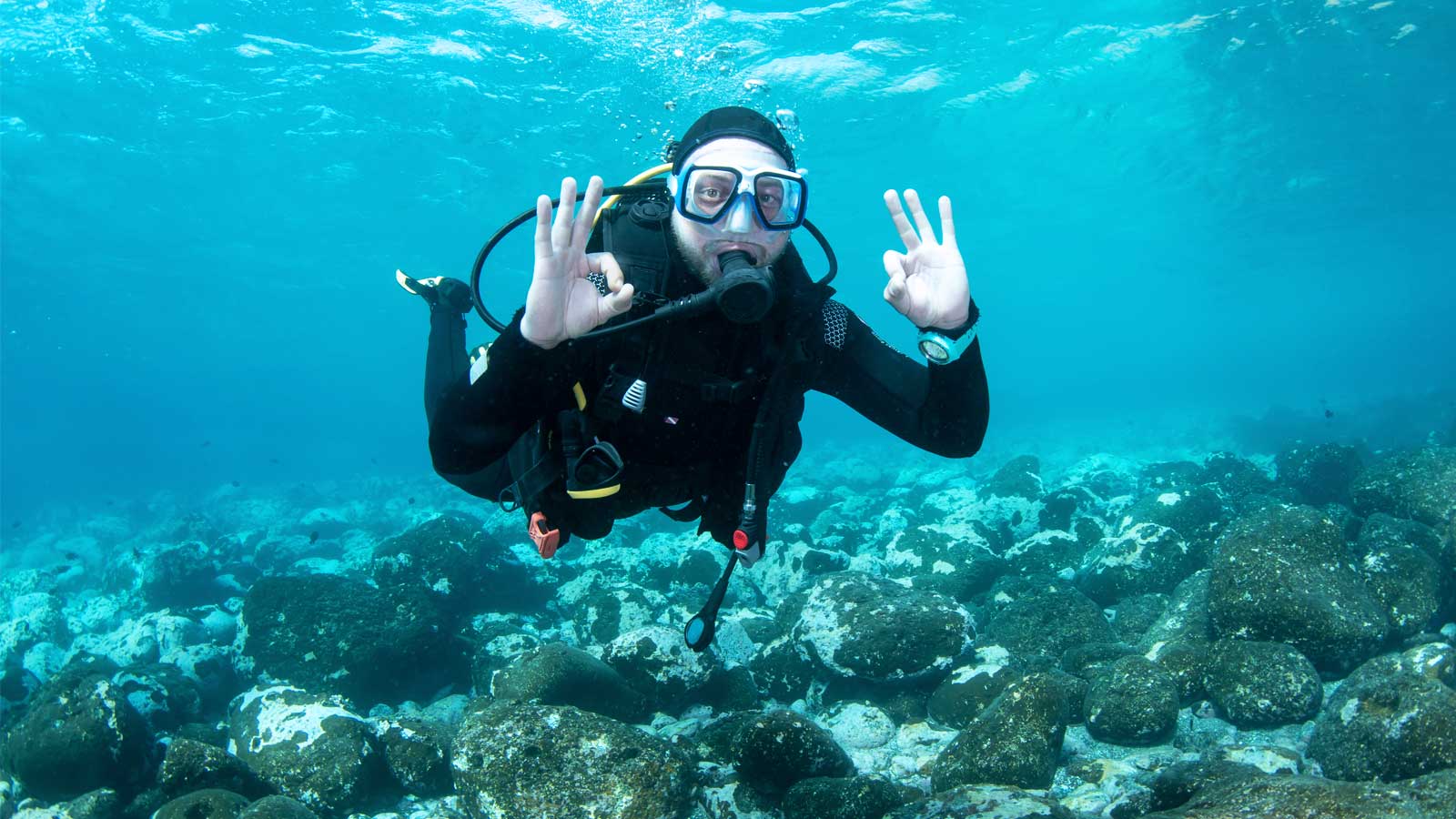 Diver signaling OK in shallow water, part of beginner diving courses offered by LoCura Diving in Tenerife