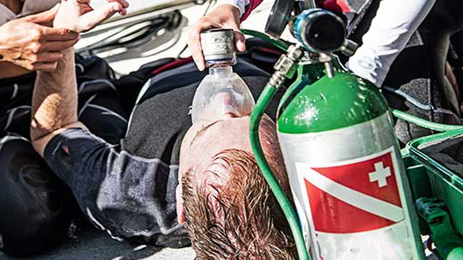 Rescue diver administering emergency oxygen to an unconscious diver, part of the rescue diver training offered by LoCura Diving in Tenerife